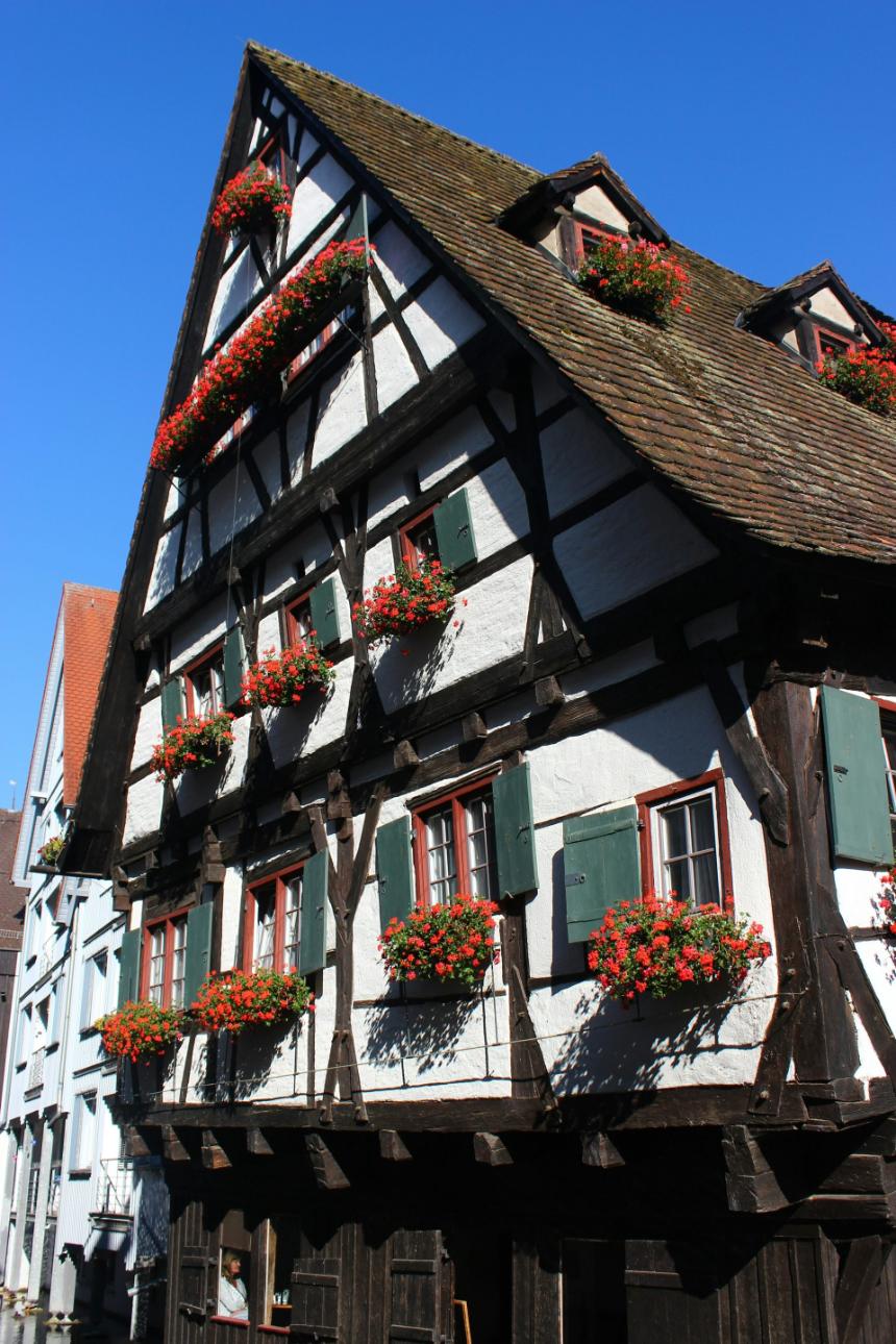 ein Gebäude mit Blumen an den Fenstern und Fensterläden